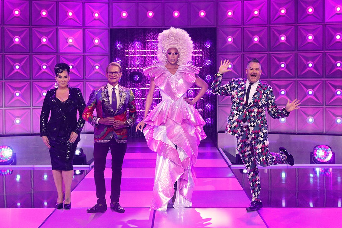 Rupaul and their fellow judges pose on a purple stage